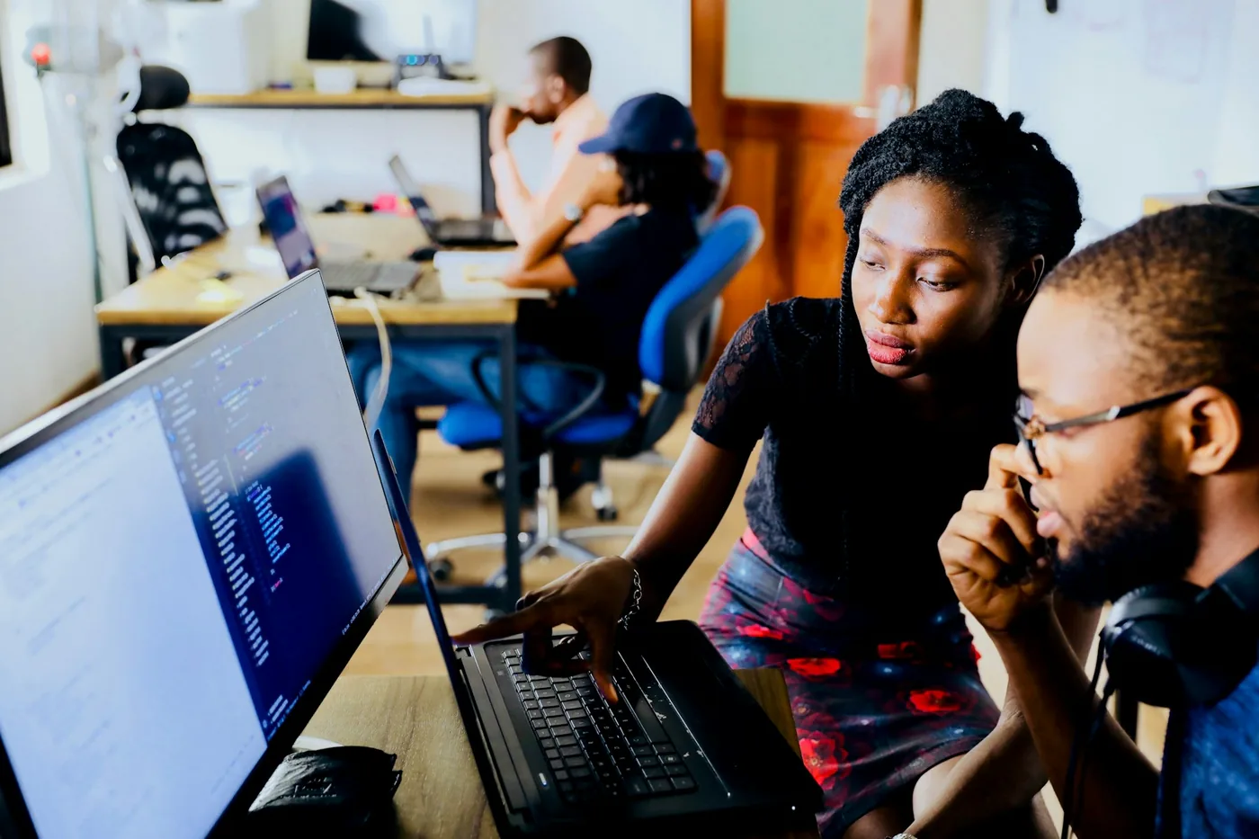 Two colleagues working through a problem together at a laptop